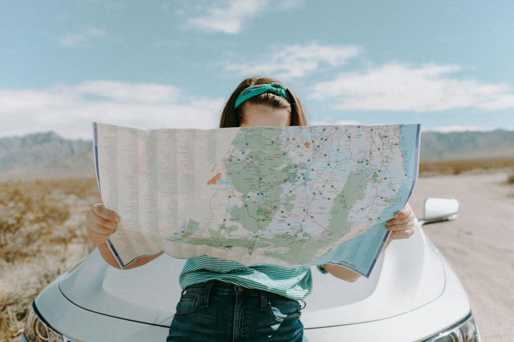 persona intenta a studiare una mappa per proseguire un viaggio in auto