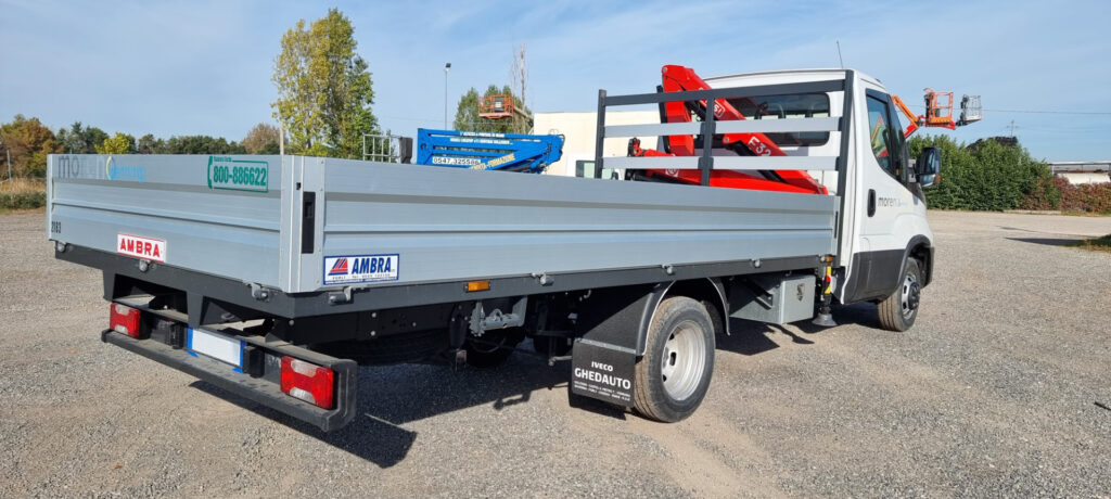 Camioncino cassonato con gru idraulica richiudibile, disponibile a noleggio per trasporto e movimentazione di materiali pesanti.